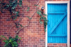 puerta de madera azul en la pared de ladrillo, efecto de filtro foto