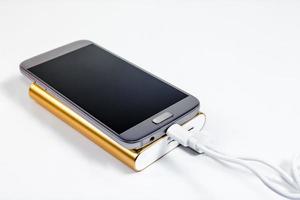 Golden powerbank with smart phone on background photo