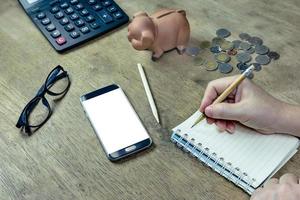 Human hand holding pencil with notepad on desktop photo