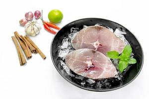 Fillet of Spanish Mackerel Slide with ice cubes on black dish ,Scomberomorus photo