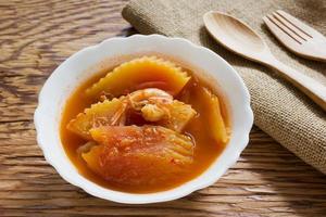 Sour curry shrimp and papaya on wood background photo