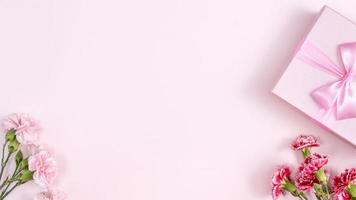 día de la madre, concepto de diseño de fondo del día de San Valentín, hermoso ramo de flores de clavel rosa y rojo en la mesa rosa, vista superior, puesta plana, espacio de copia. foto