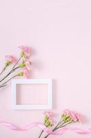 día de la madre, concepto de diseño de fondo del día de San Valentín, hermoso ramo de flores de clavel rosa en una mesa rosa pastel, vista superior, puesta plana, espacio para copiar. foto