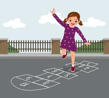 linda niñita jugando a la rayuela dibujada con tiza afuera en la calle de juegos en el parque