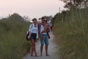 The family walks an idyllic path surrounded by tall grass. Selective focus photo