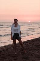 Happy Carefree Woman Enjoying Beautiful Sunset on the Beach. Selective focus photo