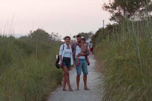 la familia recorre un camino idílico rodeado de hierba alta. enfoque selectivo foto