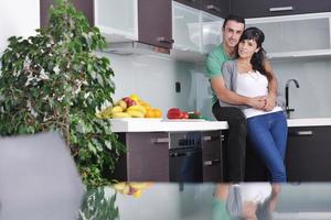 una pareja joven se divierte en la cocina moderna foto