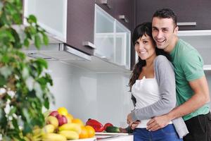 una pareja joven se divierte en la cocina moderna foto