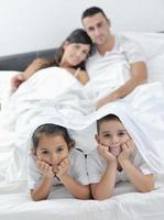 familia joven feliz en su dormitorio foto