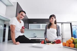 una pareja joven se divierte en la cocina moderna foto