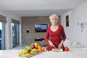 happy  beautiful blonde  woman prepare food in  the kitchen photo