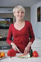 happy  beautiful blonde  woman prepare food in  the kitchen photo