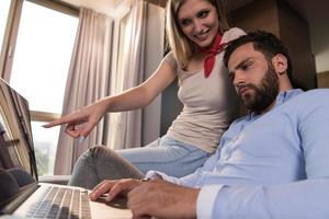 couple relaxing at  home using laptop computers photo