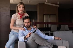 Young couple on the sofa watching television photo