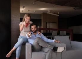 Young couple on the sofa watching television photo