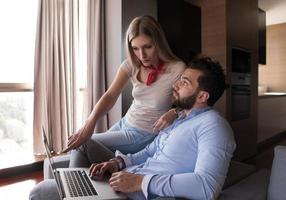 couple relaxing at  home using laptop computers photo