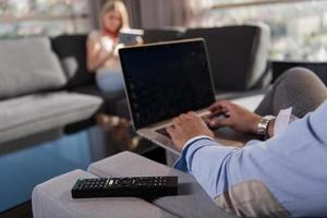 couple relaxing at  home using tablet and laptop computers photo