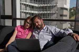 couple relaxing at  home using laptop computers photo