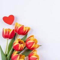 día de la madre, fondo del día de san valentín, ramo de flores de tulipán - hermoso ramo rojo, amarillo aislado en una mesa blanca, vista superior, puesta plana, concepto de diseño simulado. foto