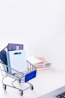 Office online paying, stay home shopping, electronic payment with credit card concept, laptop on white table background with shop cart, close up. photo