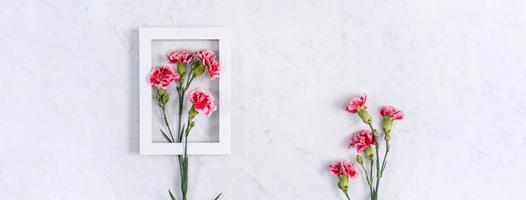 día de la madre, concepto de diseño de fondo del día de San Valentín, hermoso ramo de flores de clavel rosa y rojo en la mesa de mármol, vista superior, puesta plana, espacio de copia. foto