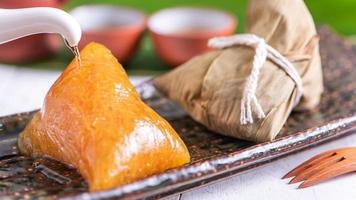 Zongzi - alkaline Chinese rice dumpling crystal food on a plate to eat for traditional Dragon Boat Duanwu Festival concept, close up. photo