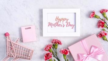 Happy Mother's Day background design concept with greeting words, beautiful pink, red carnation flower bouquet on marble table, top view, flat lay, copy space. photo