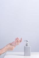 lavarse las manos. mujer joven asiática que usa jabón líquido para lavarse las manos, concepto de higiene para proteger el coronavirus pandémico aislado en fondo blanco gris, cerrar. foto