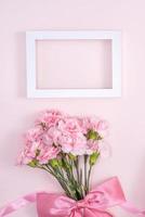 día de la madre, concepto de diseño de fondo del día de San Valentín, hermoso ramo de flores de clavel rosa en una mesa rosa pastel, vista superior, puesta plana, espacio para copiar. foto