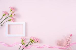 día de la madre, concepto de diseño de fondo del día de San Valentín, hermoso ramo de flores de clavel rosa en una mesa rosa pastel, vista superior, puesta plana, espacio para copiar. foto