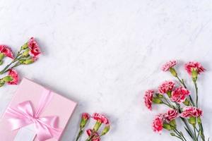 Mother's Day, Valentine's Day background design concept, beautiful pink, red carnation flower bouquet on marble table, top view, flat lay, copy space. photo