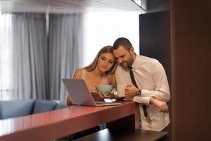 una pareja joven se prepara para un trabajo y usa una computadora portátil foto