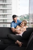 young handsome couple hugging on the sofa photo