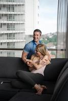 young handsome couple hugging on the sofa photo