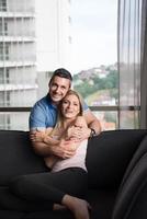 young handsome couple hugging on the sofa photo