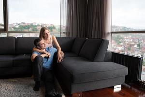 young handsome couple hugging on the sofa photo