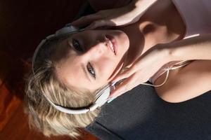Lovely Blond Woman Listening To Music while resting on couch photo