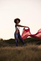 black girl dances outdoors in a meadow photo