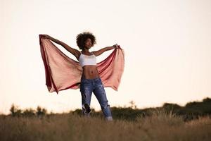 black girl dances outdoors in a meadow photo