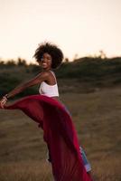 chica negra baila al aire libre en un prado foto