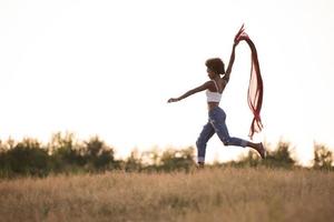 black girl dances outdoors in a meadow photo