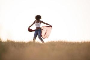 black girl dances outdoors in a meadow photo