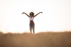 joven negra baila al aire libre en un prado foto