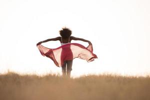 black girl dances outdoors in a meadow photo