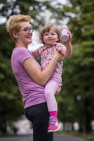 jogging madre lleva hija pequeña foto