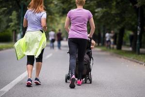 women with baby stroller jogging together photo