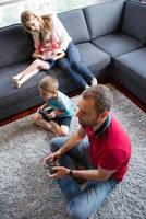 familia feliz jugando un videojuego foto