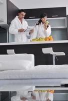 Happy couple reading the newspaper in the kitchen at breakfast photo