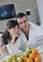 pareja feliz leyendo el periódico en la cocina durante el desayuno foto